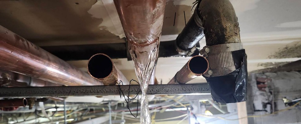 Burst pipe spraying water during a plumbing emergency